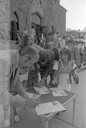 À la sortie de l'église Saint-Eugène, des citoyens signent la pétition du Comité pour la conservation de la bibliothèque. (©SHHY, fonds Jeannot Petit, P026-19730805-D001-P005)