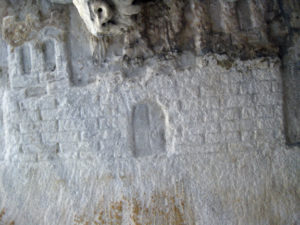 Partie des armoiries sculptées sous le fonds du sarcophage romain. On entrevoit la tête de l’aigle et les deux tours du château. (Coll. Société d’histoire de la Haute-Yamaska)