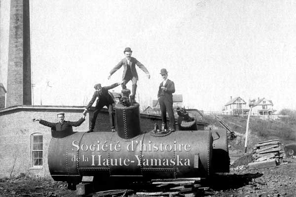 Ellis Savage et ses amis, montés sur une des chaudières à vapeur qu’on installera bientôt dans la nouvelle centrale électrique de Granby. ©Société d’histoire de la Haute-Yamaska, fonds Ellis Savage, P020-S005-P63